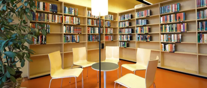 Sessel im Kreis, umgeben von Büchern