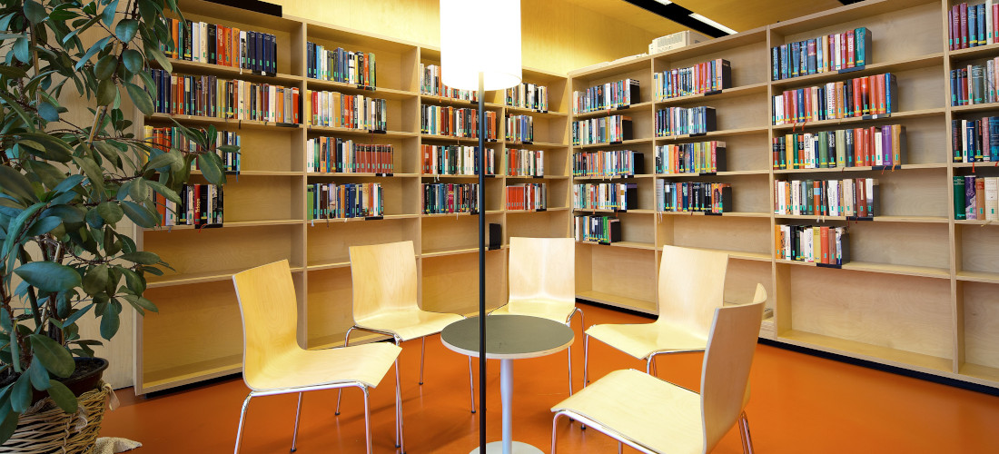 Sessel im Kreis, umgeben von Büchern